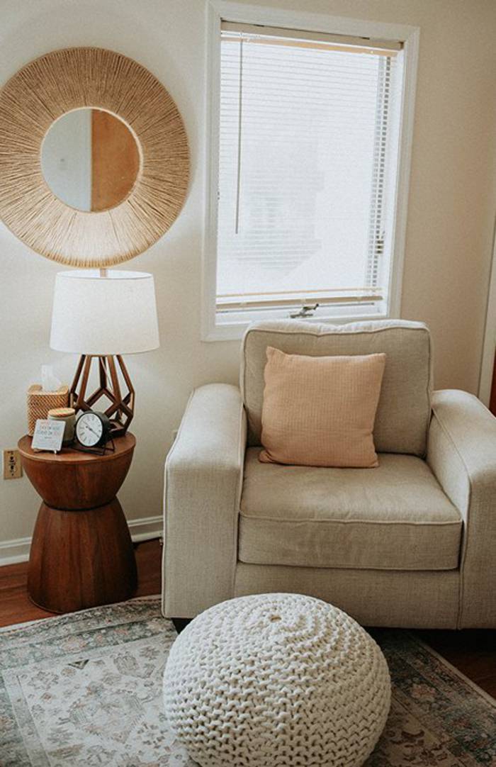 A Willow Tree therapy room with a soft armchair, a knitted floor pouf and a sunlit window.